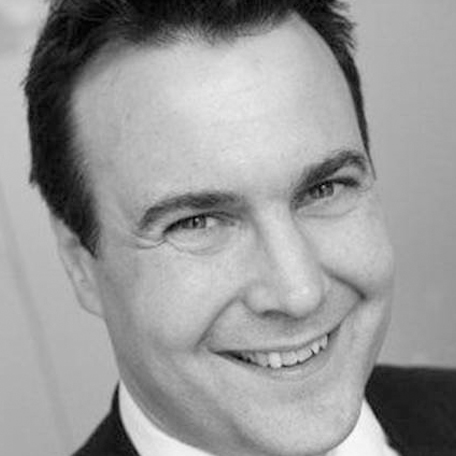 Smiling man in a black and white photograph.