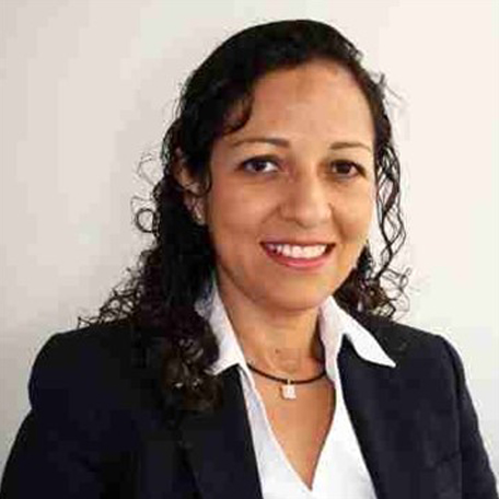 Woman smiling in a black blazer and white shirt.