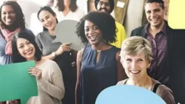 Çeşitli bir grup insan, konuşma balonları tutarak neşeyle poz veriyor.