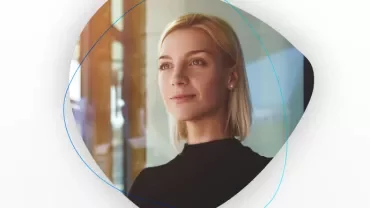 Kadın, camın önünde duruyor, geleceğe umutla bakıyor.