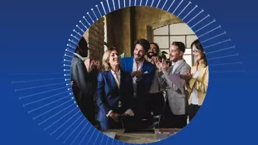 Colleagues clapping in a meeting room.