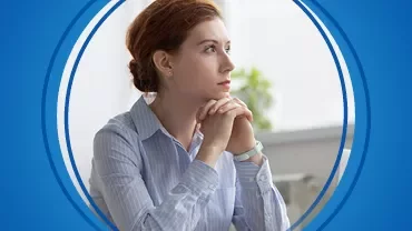 Düşünceli bir kadın mavi kenarlıklı yuvarlak çerçeve içinde.