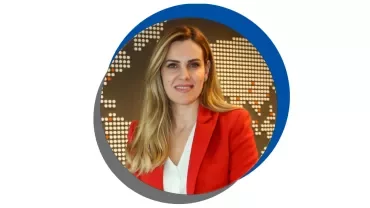 Kırmızı ceketli, beyaz bluzlu bir kadın.