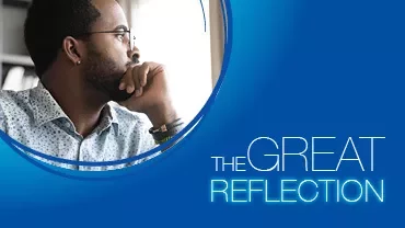 Thoughtful man gazing out a window against a blue backdrop.