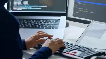 Bir kadın masada oturan robotla görüşüyor.