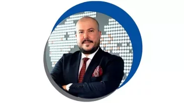 Takım elbiseli, harita arka planıyla poz veren bir adam.