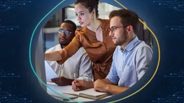 Three people collaborating in front of a computer screen.
