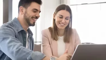 Two professionals discussing in front of a laptop