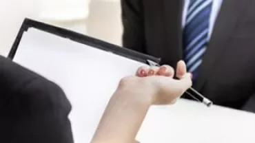 Bir iş görüşmesinde evrak tutan kişinin eli.