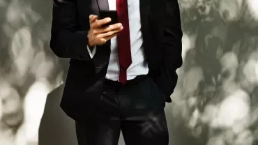 Man in suit looking at smartphone