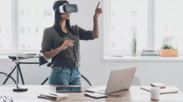 Woman using VR headset in office setting.