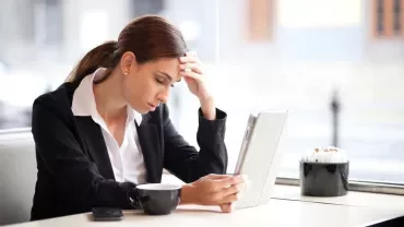 Woman in a café looking at a tablet.