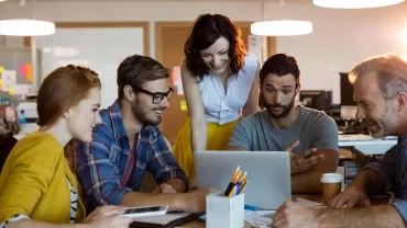 A group of people working together at a laptop.
