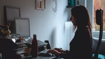 A woman working at a desk with a laptop.