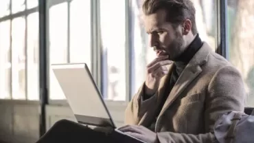 Man thinking in front of a laptop.