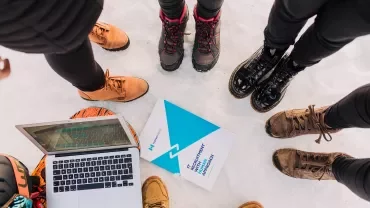 Boots in a circle on snow with a laptop.