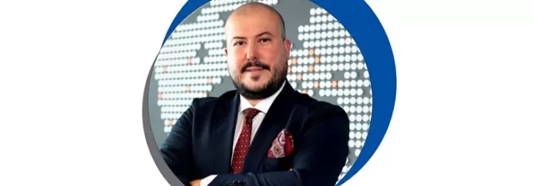 Takım elbiseli, harita arka planıyla poz veren bir adam.