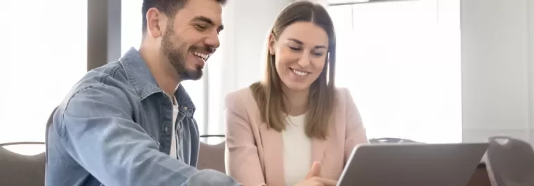 Two professionals discussing in front of a laptop
