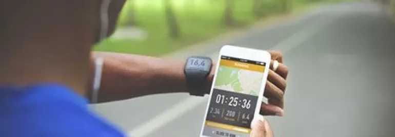 Koşu yapan biri, akıllı telefon ekranında süreyi kontrol ediyor.