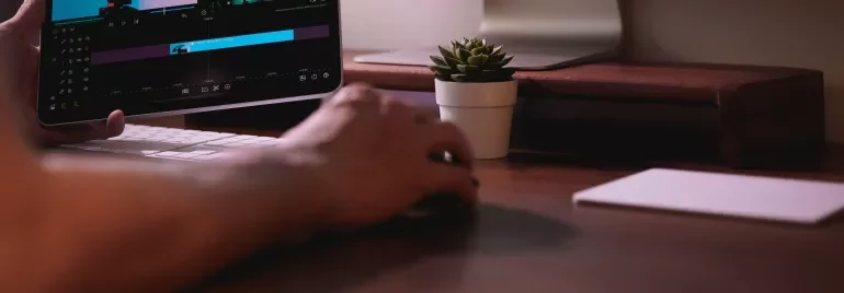 Masaüstünde bilgisayar ve video düzenleyen bir tablet.