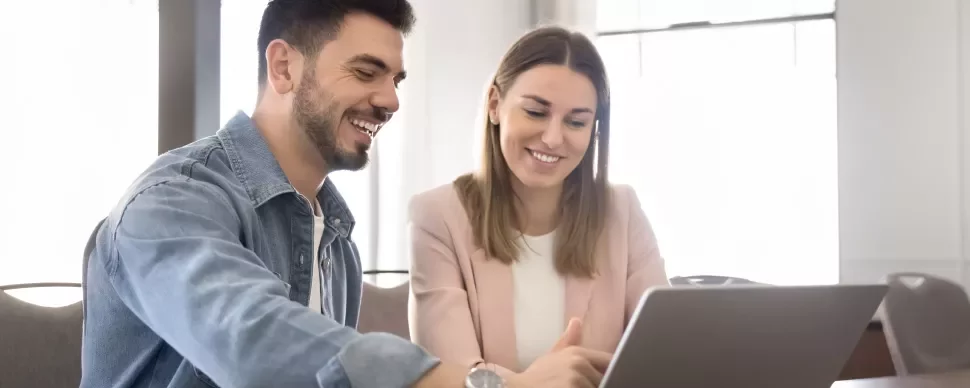 Two professionals discussing in front of a laptop