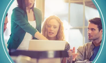 People discussing around a computer.
