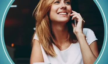 Happy woman talking on phone with a cup of coffee.