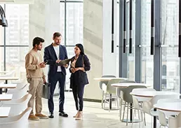 3 coworkers talking in a company lobby
