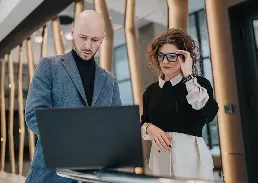 A worker and a client on a laptop