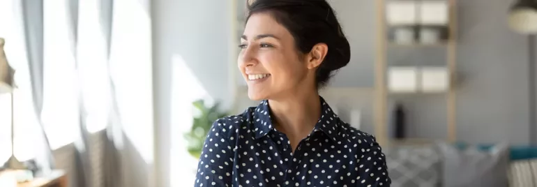 Polka dot gömlek giymiş gülümseyen bir kadın.