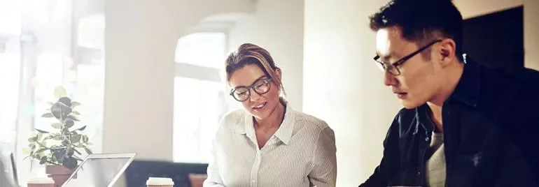 Ofis masasında çalışan iki kişi.