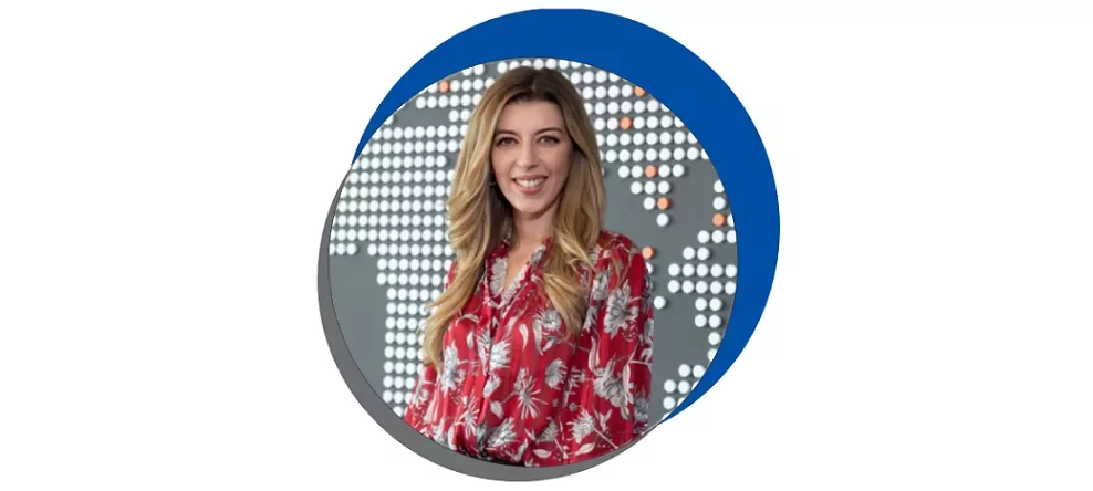 Kırmızı desenli gömlek giyen kadın, dünya haritası fonunda.