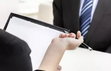 Bir iş görüşmesinde evrak tutan kişinin eli.