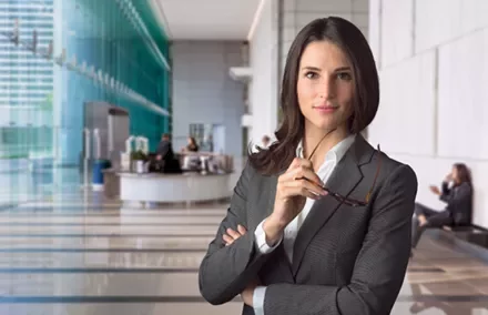 Young businesswoman posing in a modern office lobby.